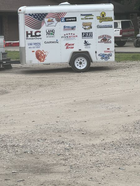 Sponsor banners and the concession trailer staged along the lot.